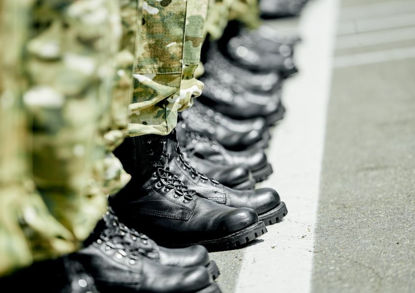 Soldiers standing in a row, photo of their legs and boots