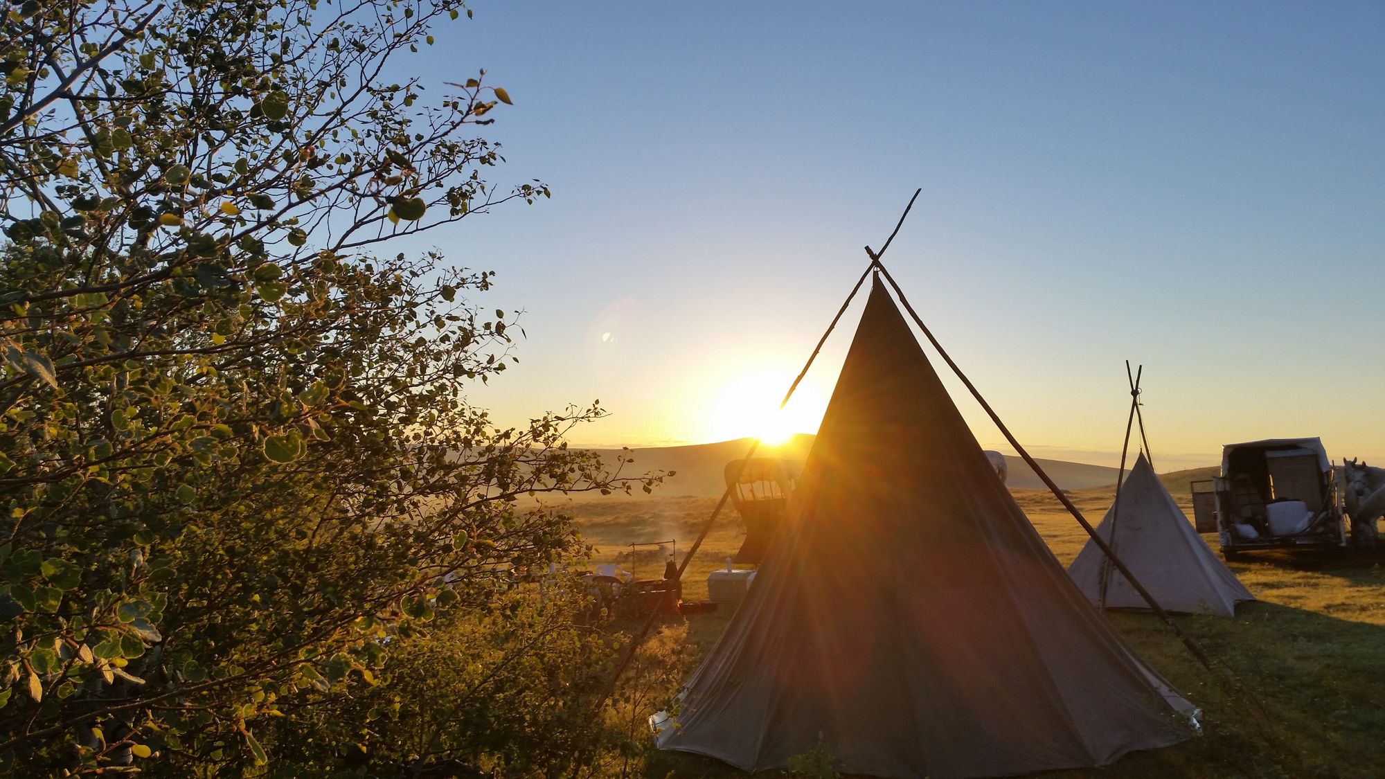 Evening sunset overlooking tents set up for overnight wilderness camping