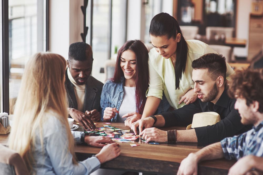 Group of friends gather around a table and play a game together