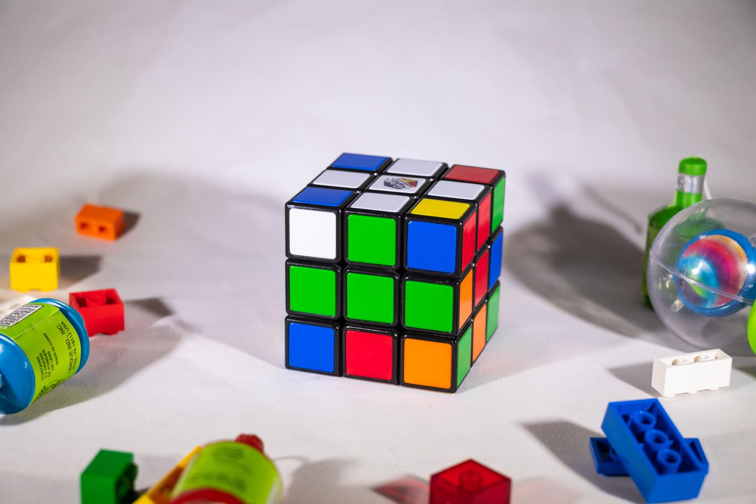 View of Rubik's Cube on white surface showing initial stage of progress completion