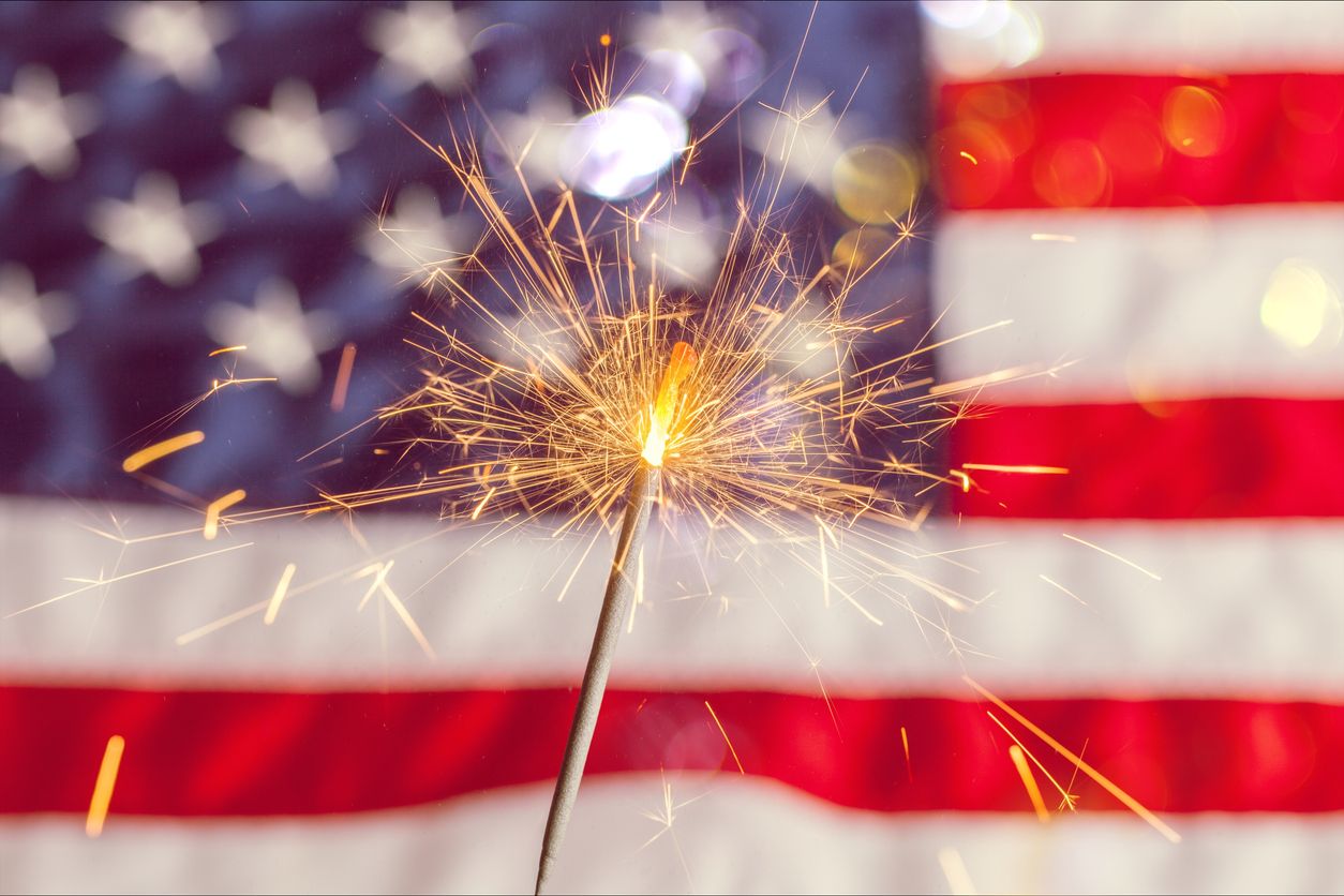 Sparkler being held in front of the American flag