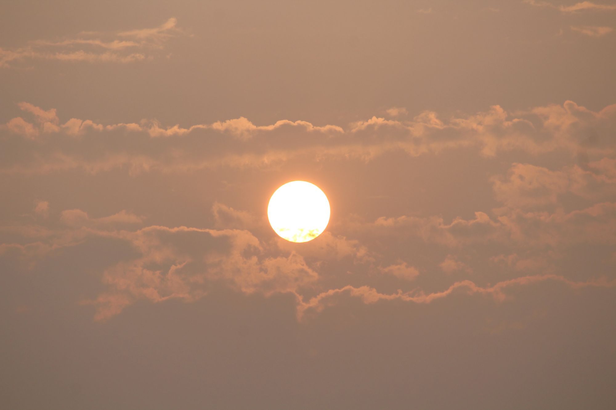 The sun shining through clouds