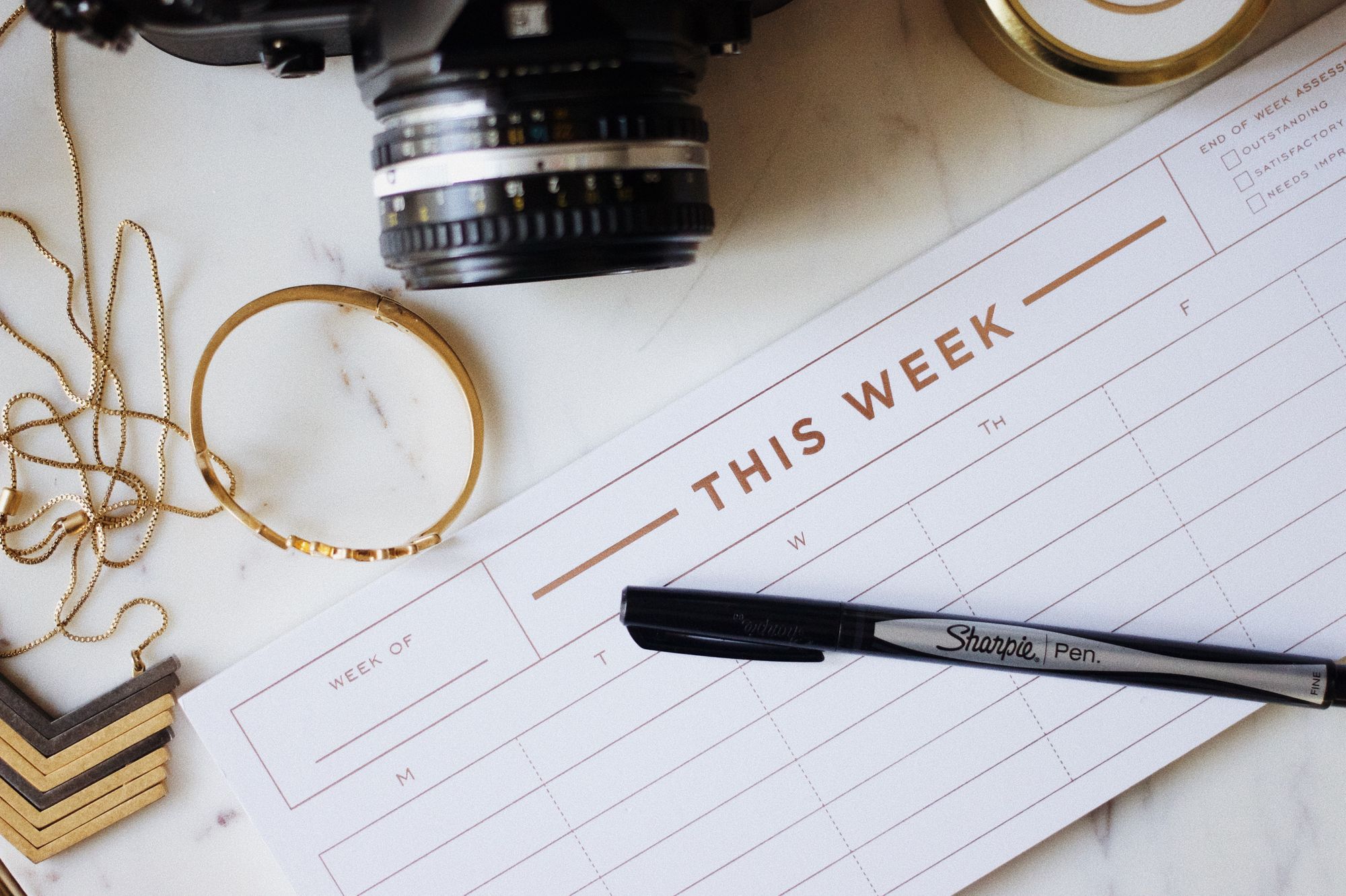 Calendar of the week with sharpie pen and camera