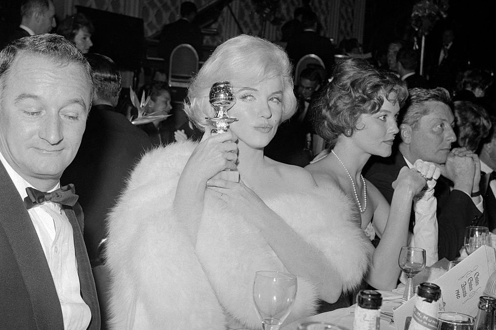 Marilyn Monroe showing off her Golden Globe award