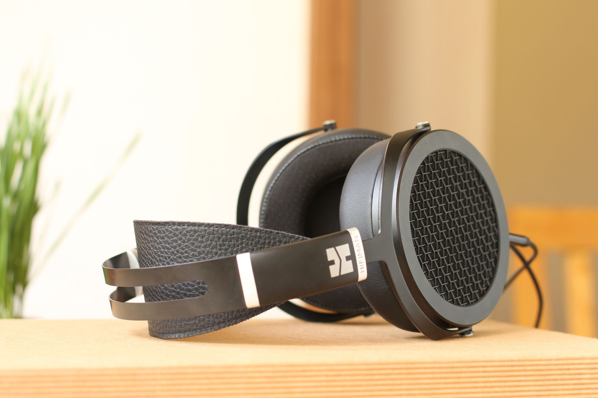 Black headphones sitting on a wooden table