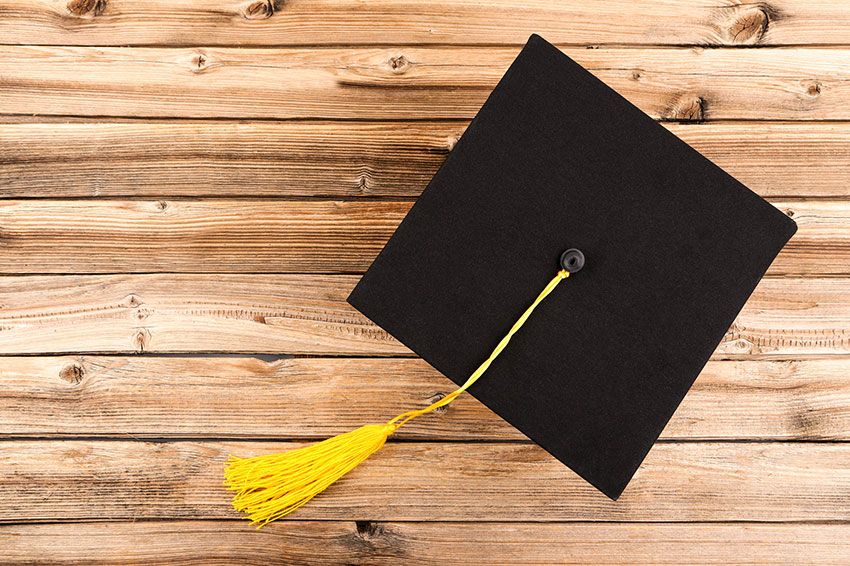 Overhead view of a graduation hat on a wooden surface.