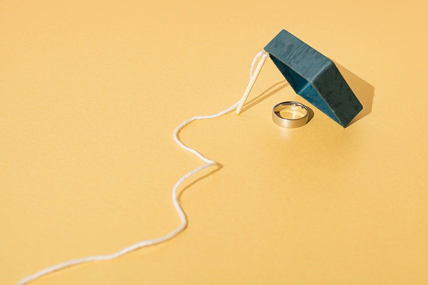 A blue box held by a stick with a rope and a wedding ring.