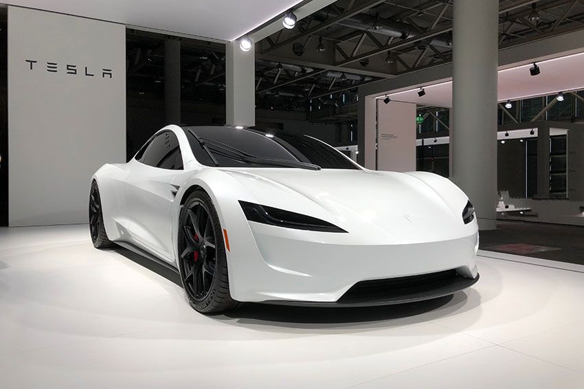 A white Tesla car on display in a showroom.