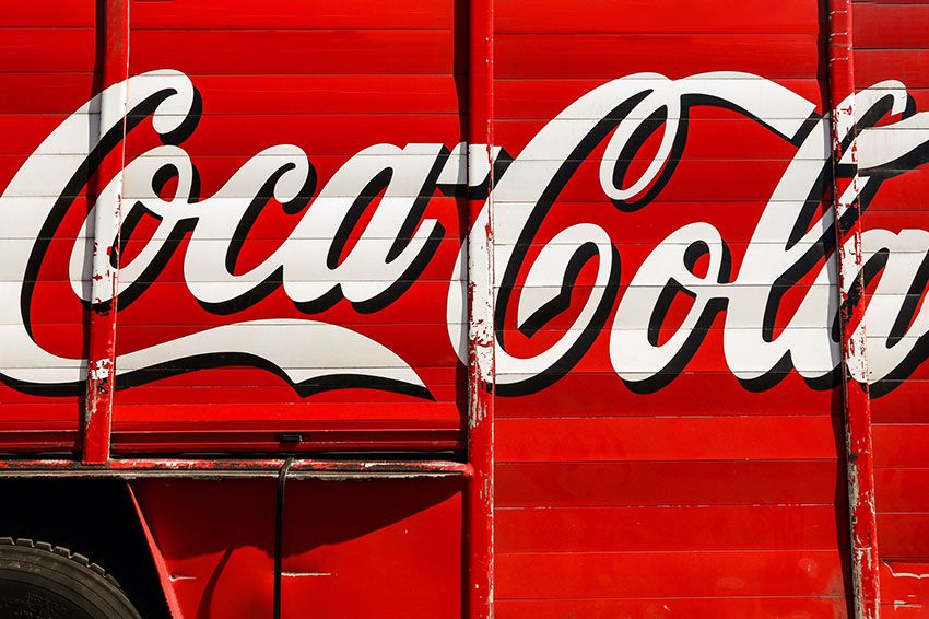 Close up of a red delivery truck that has the Coca-Cola logo.