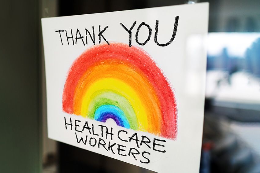 Sign posted on a window reading "Thank you healthcare workers" and a rainbow.