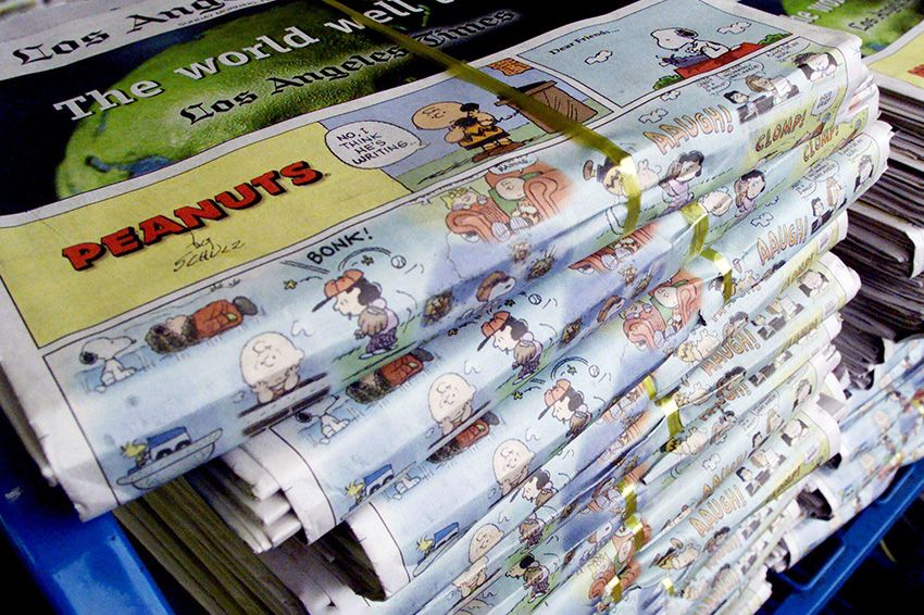 Stacks of the Sunday edition of the Los Angeles Times, with the final Sunday "Peanuts" comic strip by cartoonist Charles M. Schulz
