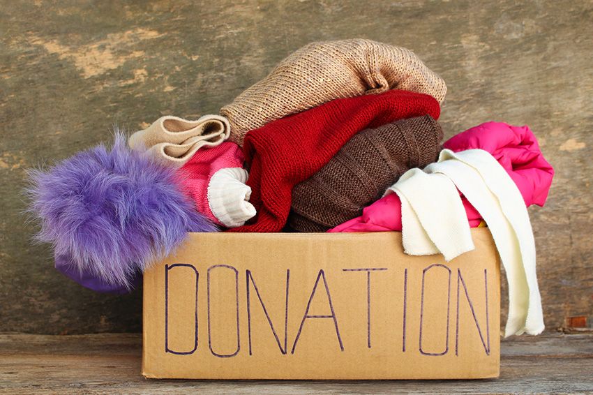 Cardboard box full of clothing with donation written on it.