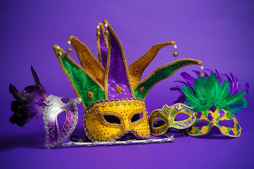 Group of Mardi Gras masks on a purple background.