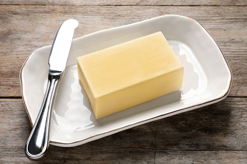 Butter and knife on a dish.